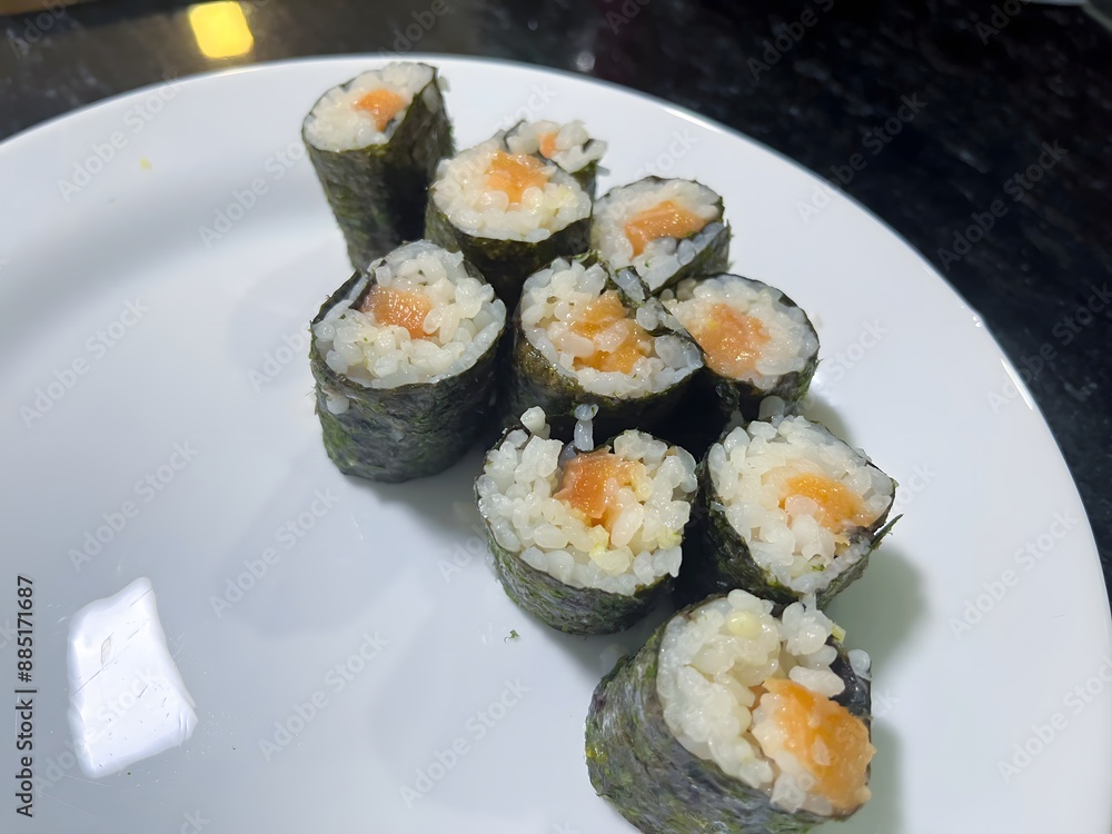 Delicious salmon sushi rolls on a white plate, fresh ingredients, perfect bites ready to be enjoyed Delicious salmon sushi rolls on a white plate, fresh ingredients, perfect bites ready to be enjoyed