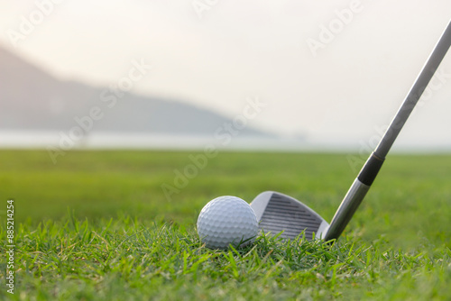 Golf clubs and golf balls on a green lawn in a beautiful golf course