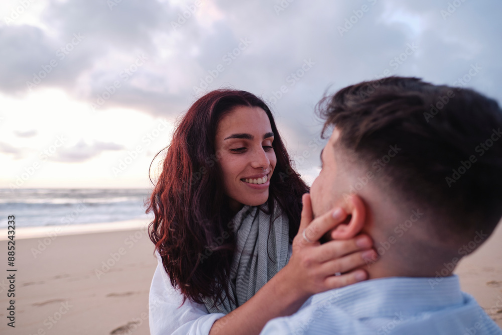 Romantic woman touching boyfriend's face at beach Romantic woman touching boyfriend's face at beach