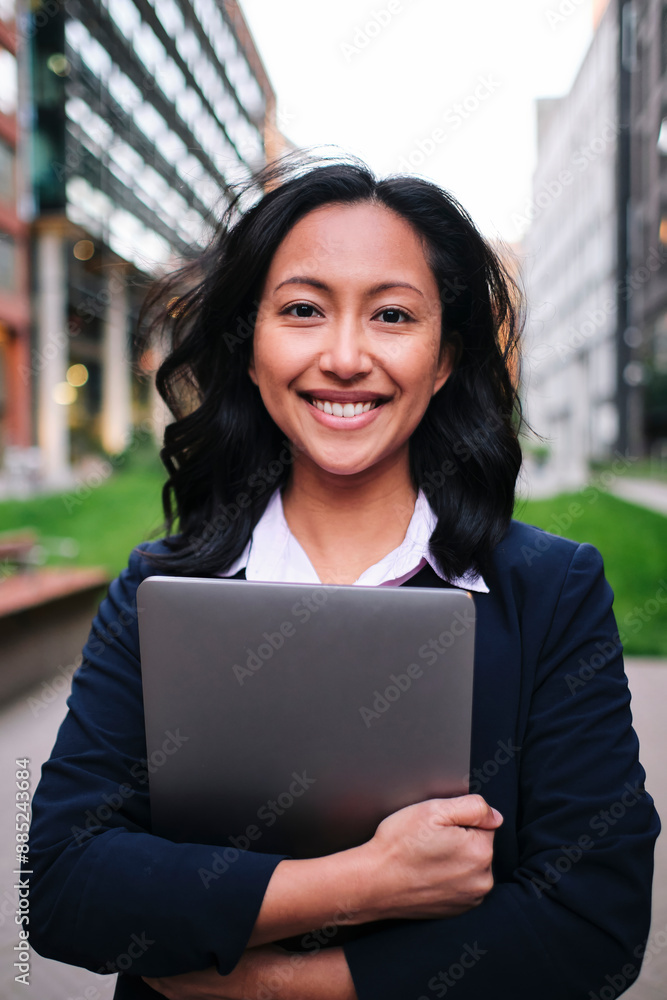 Confident businesswoman with medium-length hair holding laptop Confident businesswoman with medium-length hair holding laptop