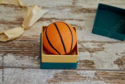 Obraz na plátně Basketball in jewelry gift wrap on the table close-up, gift for fan, start of ch