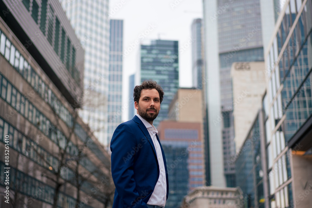 Confident businessman standing in front of modern buildings