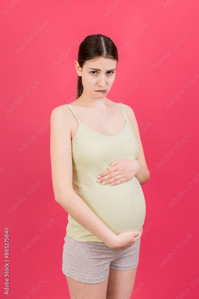 Sad and stressed pregnant woman isolated on colored background Sad and stressed pregnant woman isolated on colored background