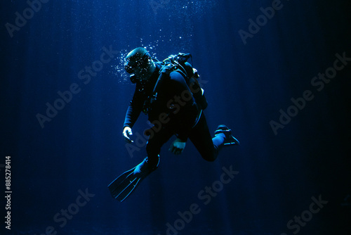 Diver  swimming in the blue water with the aqualung 