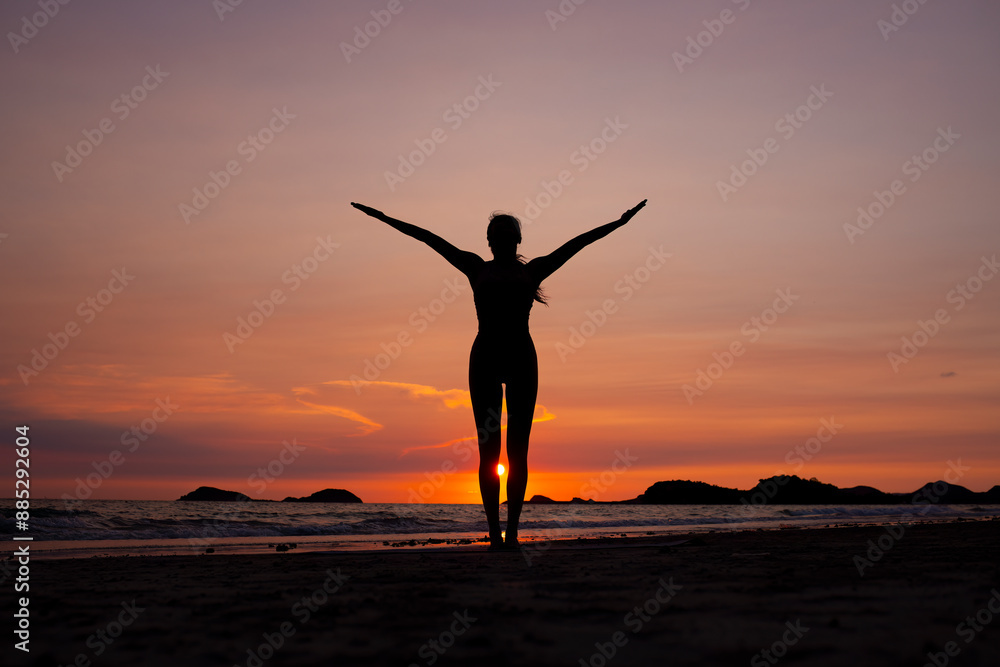 Silhouette of sport woman performing a yoga pose on the beach at sunset, with the sun setting behind the horizon and the calm sea .Yoga is meditation and healthy sport relaxing on summer holiday Silhouette of sport woman performing a yoga pose on the beach at sunset, with the sun setting behind the horizon and the calm sea .Yoga is meditation and healthy sport relaxing on summer holiday