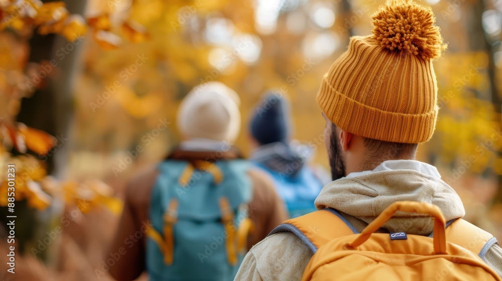 A group of hikers wearing warm beanies treks through a forest in fall, with colorful leaves highlighting the close friendship and joy of outdoor adventures. A group of hikers wearing warm beanies treks through a forest in fall, with colorful leaves highlighting the close friendship and joy of outdoor adventures.