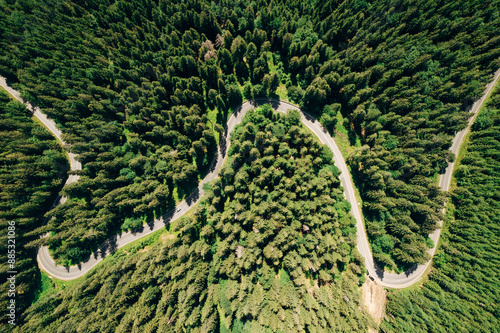 Aerial view of the road passing through the mountain and green forest. Curve asphalt road on mountain. 