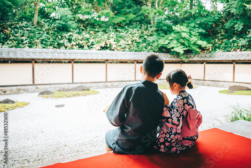 春風萬里荘の縁側に仲良く座る浴衣の男の子と女の子