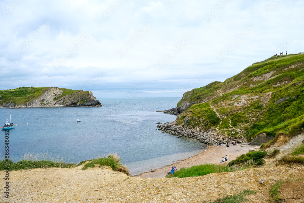Lulworth Cove bay, beach and cliffs view . The Jurassic Coast is a World Heritage Site on the English Channel coast of southern England. Dorset, UK. crowded beach, public beach.