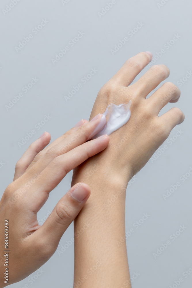 Beautiful woman's hand applying cream on back of hand, applying lotion on skin. Close-up in light background. Skin care concept, try anti-irritant cream Beautiful woman's hand applying cream on back of hand, applying lotion on skin. Close-up in light background. Skin care concept, try anti-irritant cream