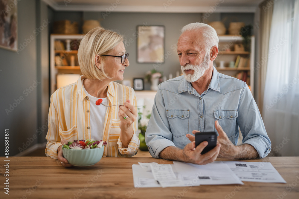 Senior couple read paper bills and invoice and discuss about payments Senior couple read paper bills and invoice and discuss about payments