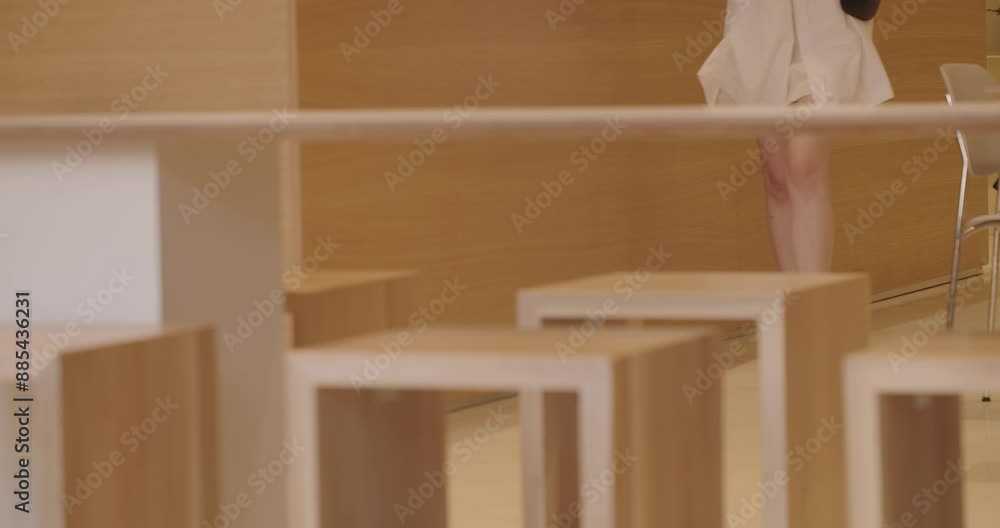 A glimpse into a modern cafe with minimalistic wooden furniture and the legs of a customer, adding a human element of daily life. calm atmosphere often found in stylish urban eating spaces. A glimpse into a modern cafe with minimalistic wooden furniture and the legs of a customer, adding a human element of daily life. calm atmosphere often found in stylish urban eating spaces.