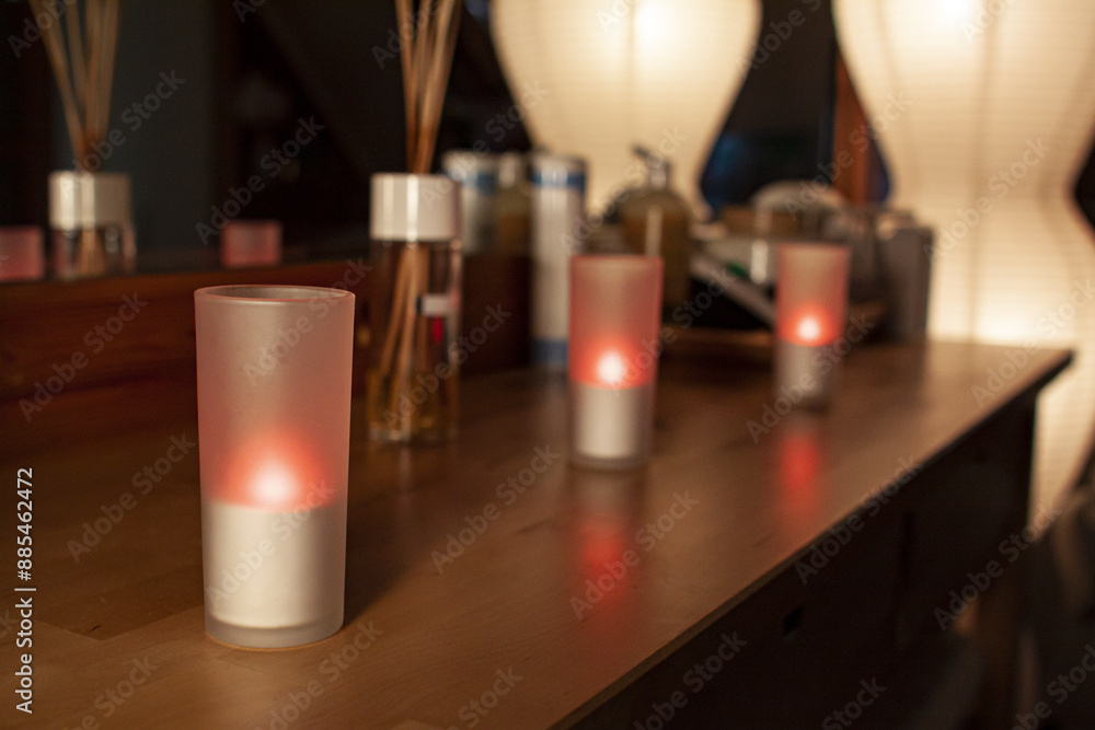 Beauty salon, spa and wellness center : glass candles on table with decorative accessories and lights Beauty salon, spa and wellness center : glass candles on table with decorative accessories and lights