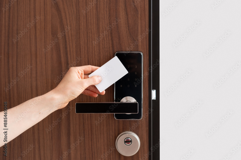 © brizmaker - Hand using key card to unlock door in hotel room or apartment