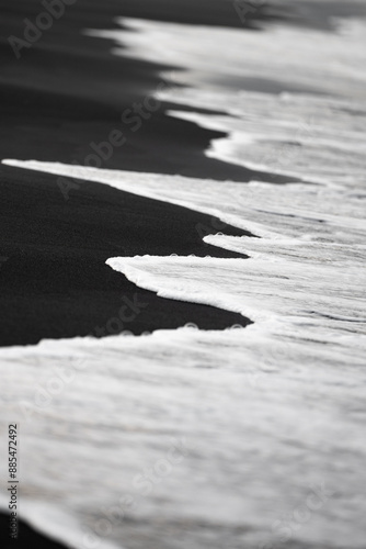 Obraz na płótnie Close-up view of some waves crashing on a black sand beach. Natural background, wallpaper. Iceland. w salonie