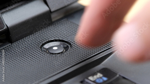 Obraz na plátně Man's finger reaching to press a generic laptop computer power button, about to