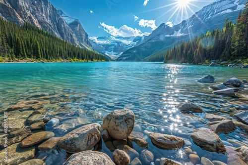 pristine alpine lake with crystalclear turquoise water sundappled boulderstrewn shore lush pine forest snowcapped mountains blue sky photo