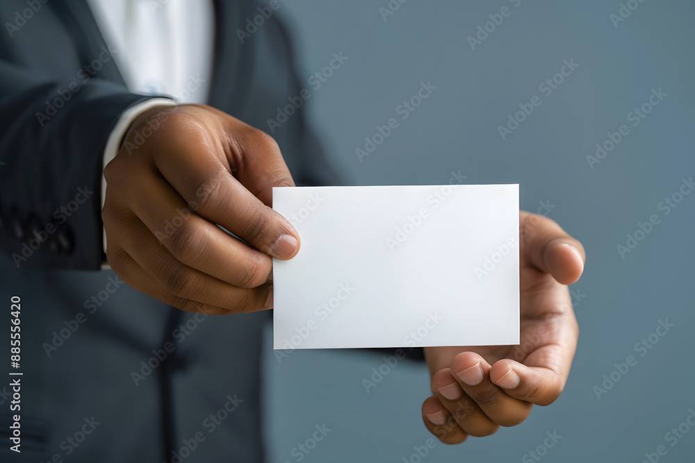 A plain background with a close-up of a male hand holding a voting ballot A plain background with a close-up of a male hand holding a voting ballot