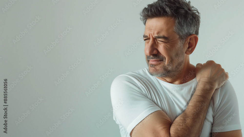 An older man holding his shoulder, showing discomfort or pain. The image highlights issues like arthritis or muscle strain common in older adults. An older man holding his shoulder, showing discomfort or pain. The image highlights issues like arthritis or muscle strain common in older adults.