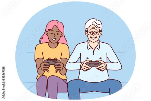 Diverse man and woman with joysticks are sitting on sofa playing game fighting virtual characters. Elderly human and African American girl play multiplayer console game spending weekend together