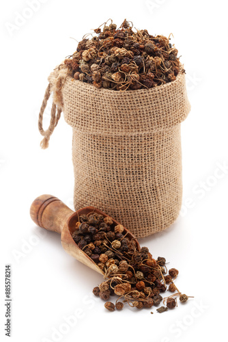 Close-up of dry Organic Black nightshade or Makoy (Solanum nigrum) fruit, in a jute bag and on a scoop, Isolated on a white background. photo