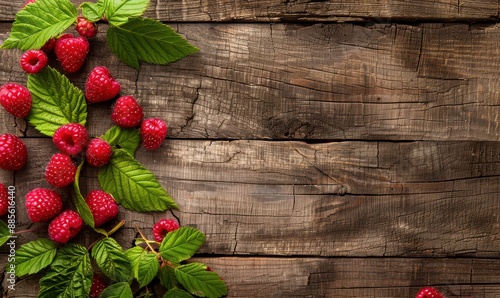 A bunch of red raspberries are on a wooden table. Free copy space for banner.