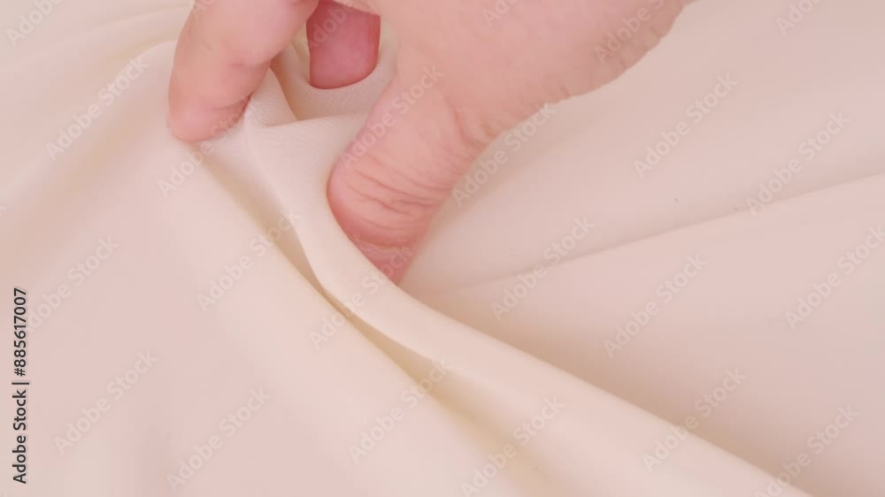 Female hands inspecting silk texture and quality delicate chiffon, crepe, hand feels sensual tactile pleasure, testing for durability, stretch and crease resistance