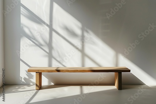 Minimalist empty wooden bench in a bright room with shadows