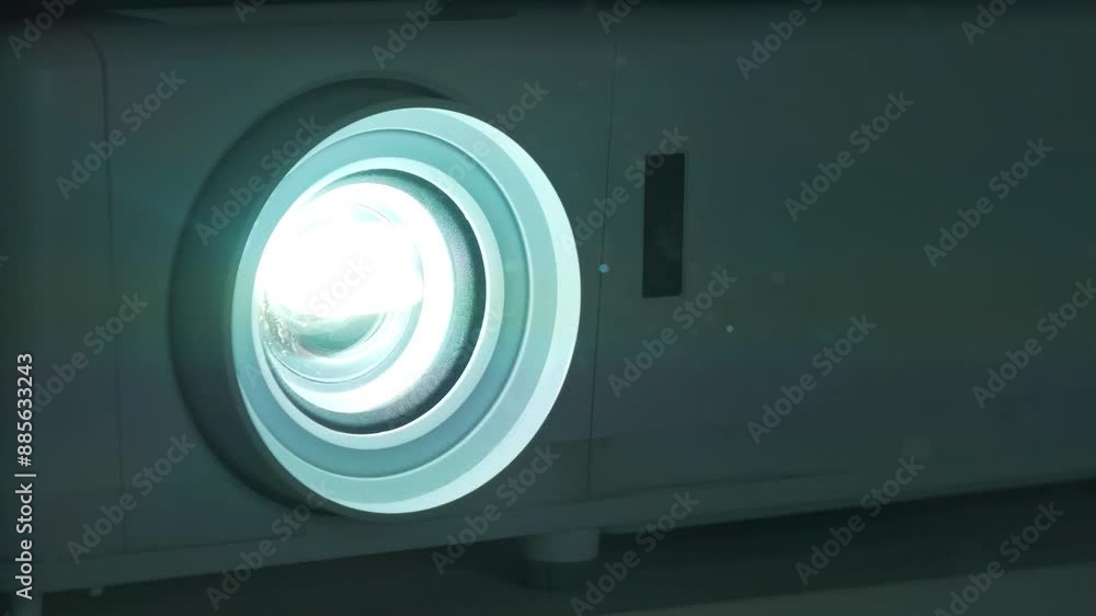 Projector lens in operation. Dust near projector in cinema hall is visible in rays of light Projector lens in operation. Dust near projector in cinema hall is visible in rays of light