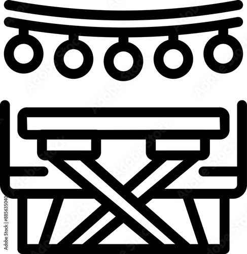 Folding camping table illuminated by string lights for an outdoor evening party