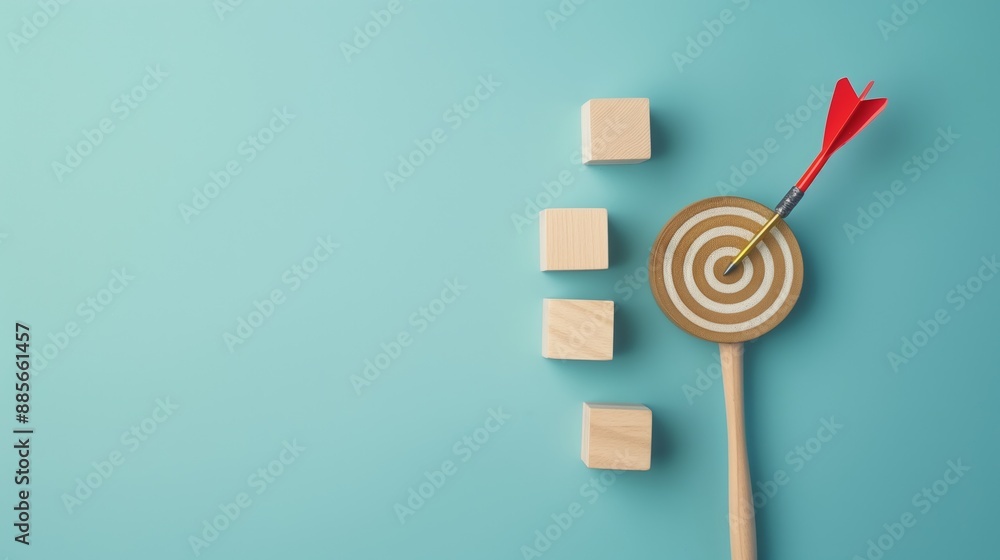 Red dart hitting a bullseye on a target with three wooden cubes on a blue background symbolizing focus, precision, and achievement. Red dart hitting a bullseye on a target with three wooden cubes on a blue background symbolizing focus, precision, and achievement.