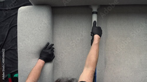 Extracting dust and dirt, removing spots from sofa using extractor to clean upholstered furniture 4k video. Refreshing sofa and cushions from dust and dirt with dry-cleaning extractor.