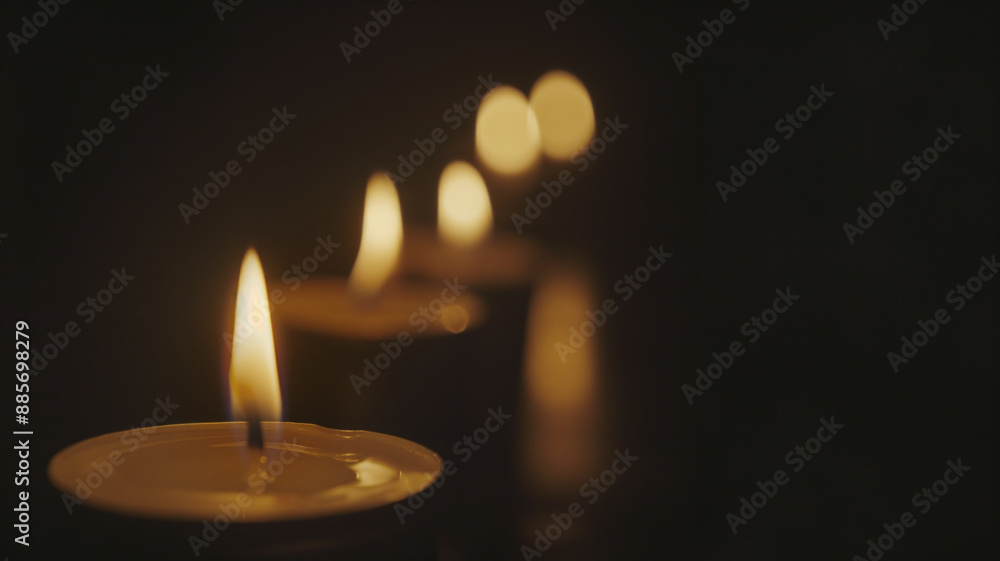 Lit candles in dark room creating warm and serene atmosphere. Soft glow of flames adds sense of calm and tranquility Lit candles in dark room creating warm and serene atmosphere. Soft glow of flames adds sense of calm and tranquility