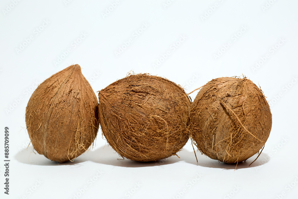 Three Coconuts Arranged on White Surface