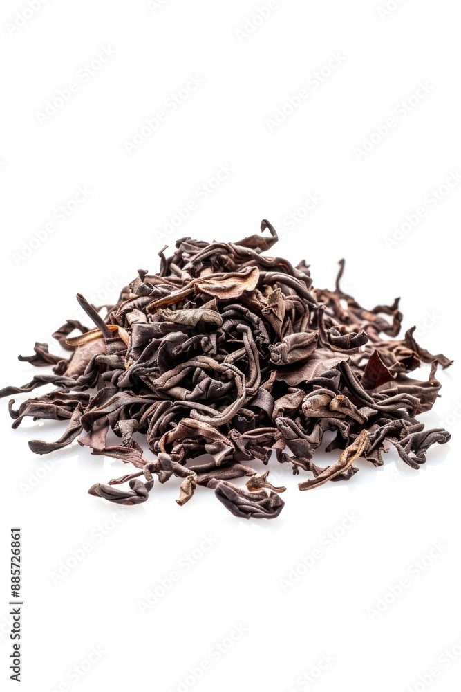 A pile of dried tea leaves on a white surface A pile of dried tea leaves on a white surface