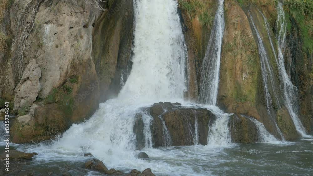 Clean water flows down in a small waterfall in slow motion. 
