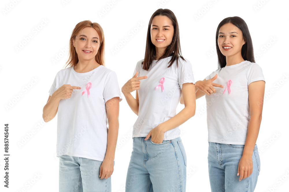 Obraz premium Beautiful women pointing at awareness pink ribbons on white background. Breast cancer concept