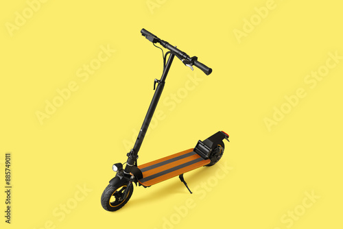 Modern electric kick scooter on yellow background