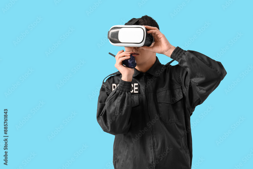Male police officer in VR glasses with two-way radio on blue background Male police officer in VR glasses with two-way radio on blue background