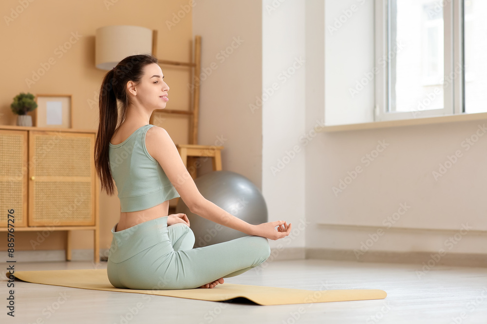 Beautiful young happy sporty woman meditating at home Beautiful young happy sporty woman meditating at home