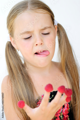 a mischievous, cheerful little girl with freckles rejoices and makes faces