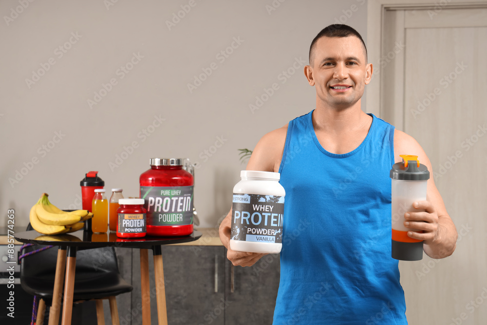 Sporty muscular man with protein powder and shake in kitchen Sporty muscular man with protein powder and shake in kitchen