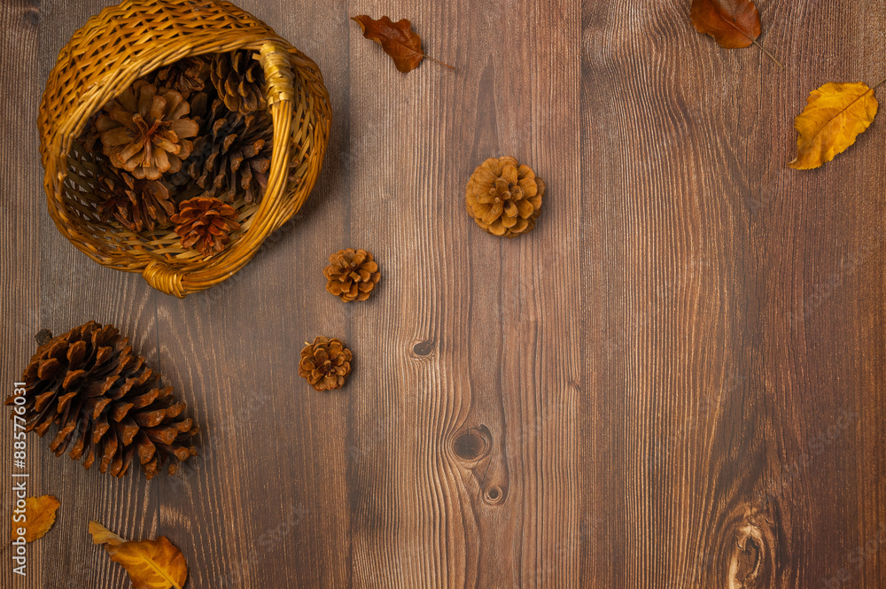 Basket with cones and nuts on wooden background. Autumn composition. Top view, flat lay Basket with cones and nuts on wooden background. Autumn composition. Top view, flat lay