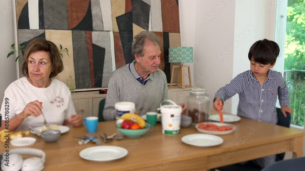 Family breakfast with elderly couple and young boy, emphasizing the warmth and connection of multigenerational bonding in a cozy home Family breakfast with elderly couple and young boy, emphasizing the warmth and connection of multigenerational bonding in a cozy home