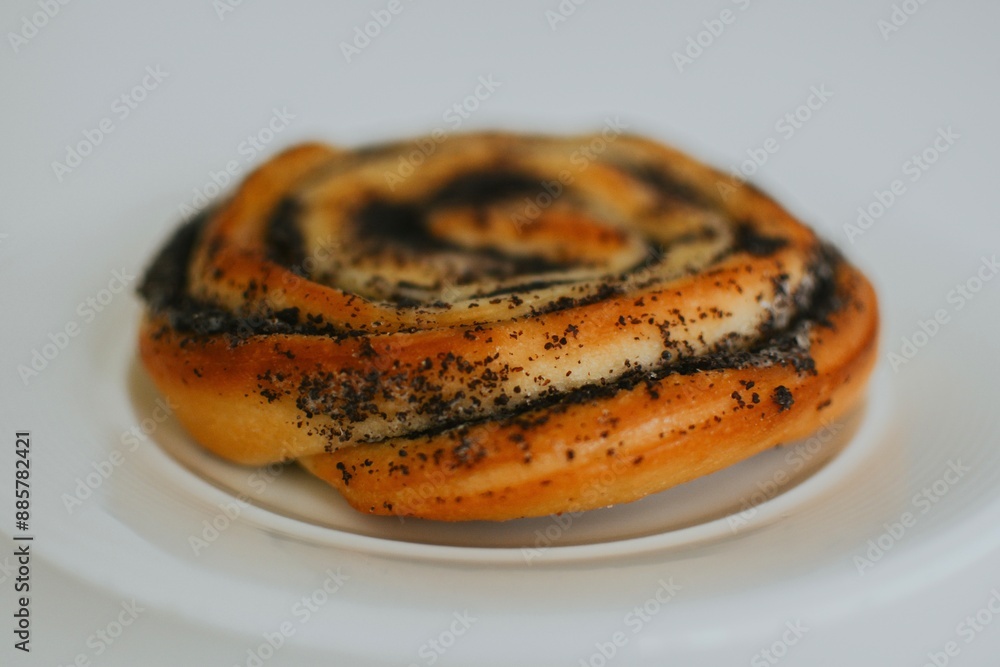 delicious macro bun with poppy seeds just out of the oven on a plate in a cafe on a white background delicious macro bun with poppy seeds just out of the oven on a plate in a cafe on a white background
