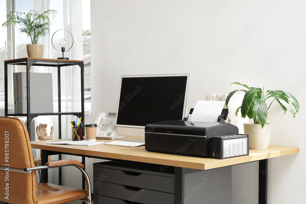 Modern workplace with computer and printer near light wall in office Modern workplace with computer and printer near light wall in office