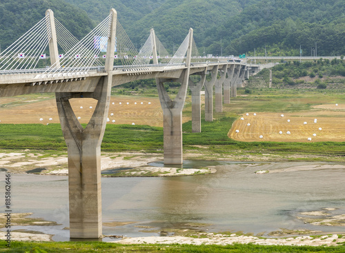 Gwandae-ri, Inje-gun, Gangwon-do, South Korea - July 1, 2017: High angle view of 38 Bridge with cable and pillars on the water of Soyangho Lake in drought
 photo