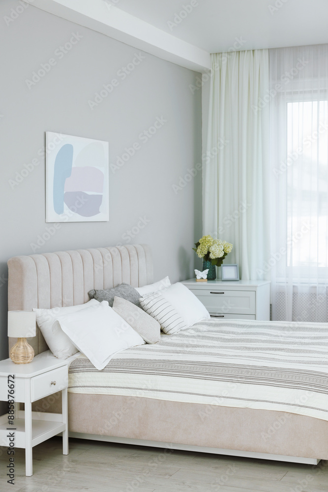 Large bed, nightstand, chest of drawers and window with curtains in bedroom. Interior design Large bed, nightstand, chest of drawers and window with curtains in bedroom. Interior design