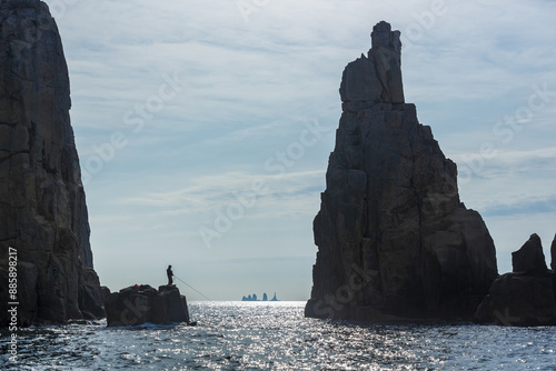 Tongyeong-si, Gyeongsangnam-do, South Korea - April 8, 2017: Morning view of a male angler fishing on the reef against sea horizon at Somaemul Island
 photo