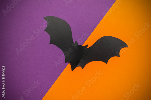 Black Paper Bat on Vibrant Purple and Orange Background for Halloween Decorations